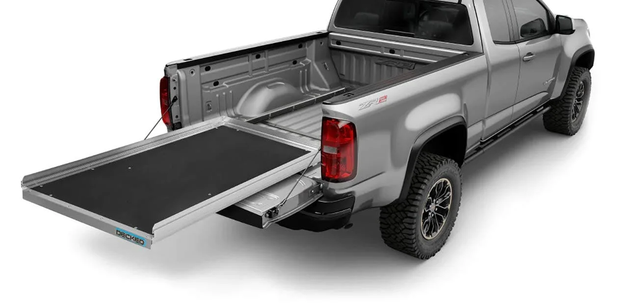 Black bed tray slide extended from silver pickup truck bed, showing open truck bed behind it