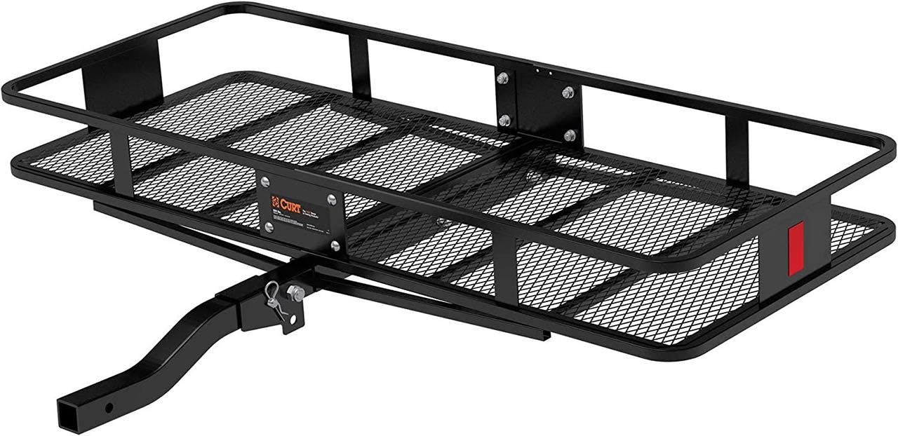 Black steel hitch-mounted cargo basket with expanded metal deck and side rails, featuring a curved tow hitch attachment.