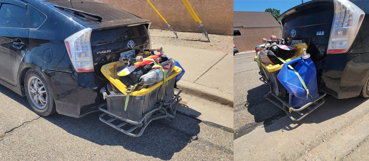 Yellow and blue hitch-mounted cargo baskets loaded with sports equipment attached to vehicle rear bumpers in a parking lot