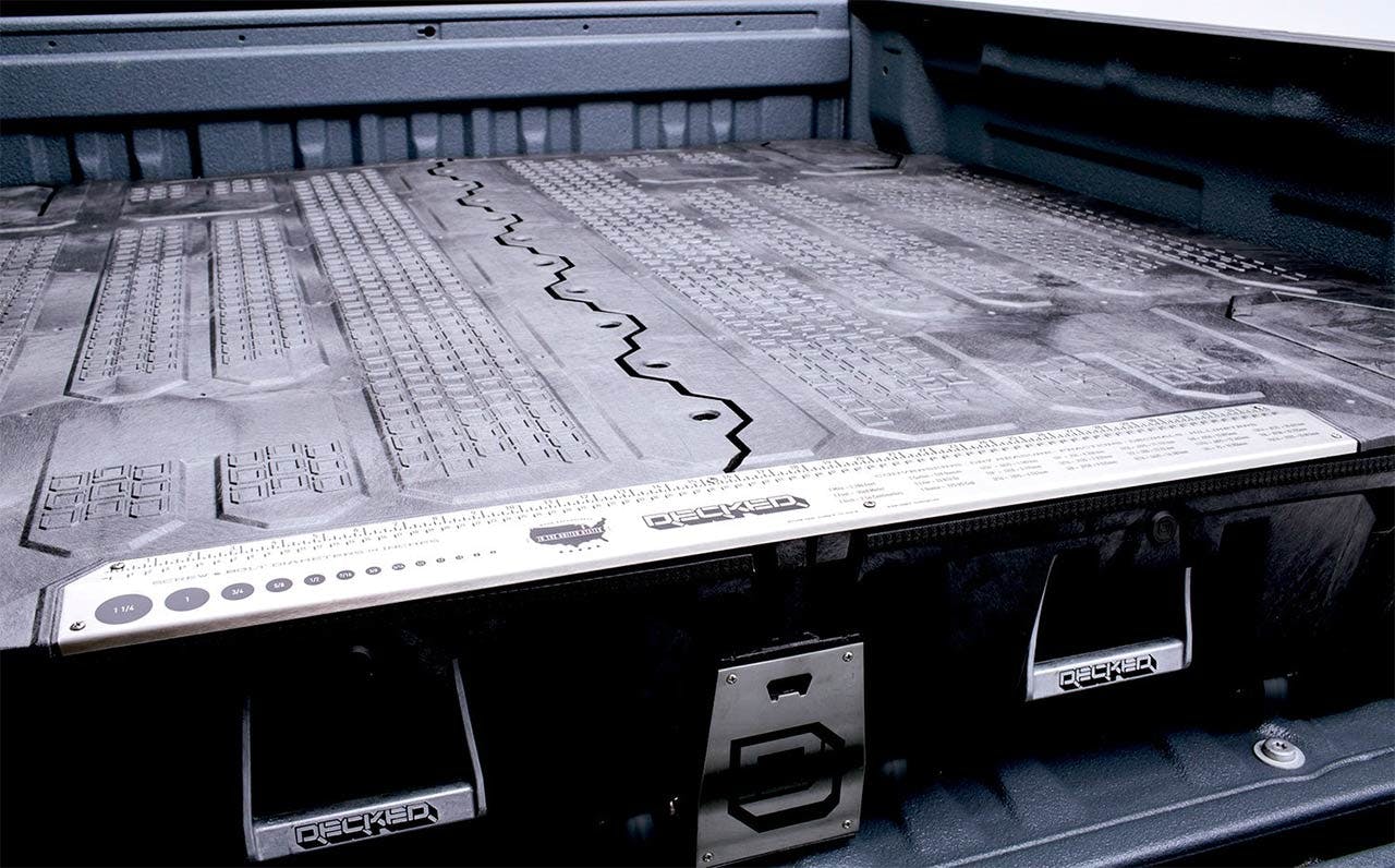 Decked drawer system installed in truck bed showing integrated storage drawers with waffle pattern surface and measurement