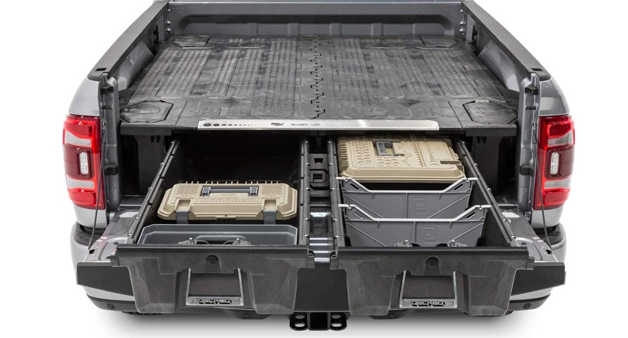 Open truck bed showing a sliding drawer system with tan and black storage containers installed on both sides