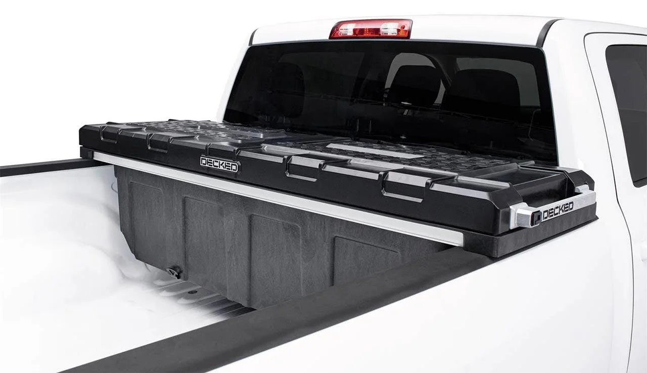 Black Decked truck bed storage system with sliding drawers installed in white pickup truck bed