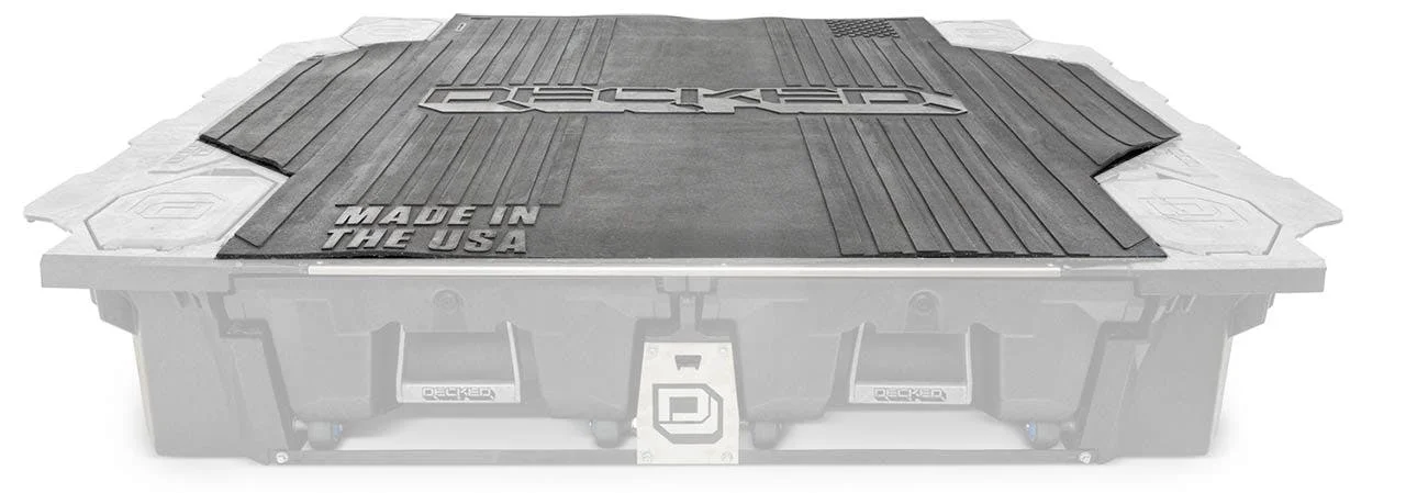 Black rubber truck bed mat with ribbed surface and Made in the USA text, fitted over bed rails