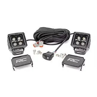 Two square LED work lights with wiring harness, control switch, and mounting brackets for truck installation