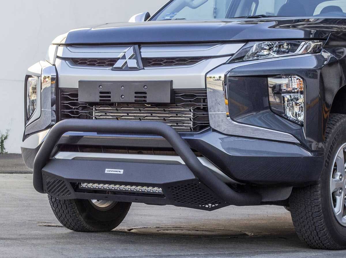 Black bull bar with integrated LED light strip mounted on silver Mitsubishi truck front bumper