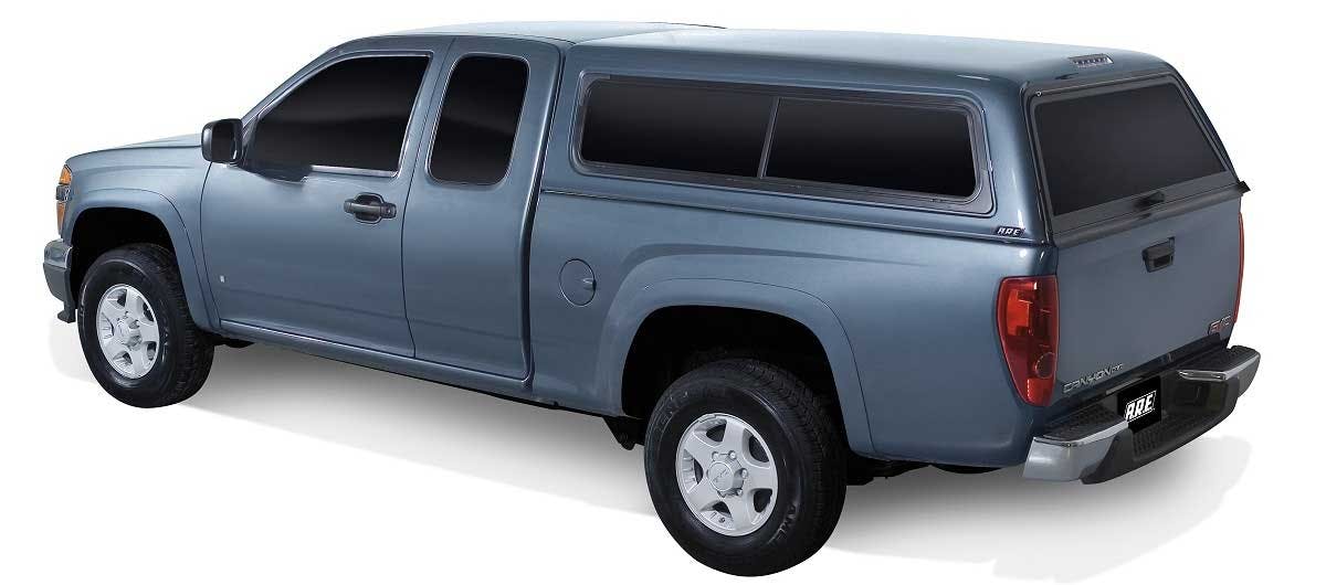 Blue pickup truck with extended cab and black tonneau cover over the bed, shown from the side angle