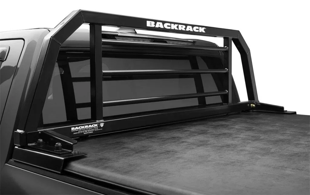 Black steel headache rack mounted on pickup truck bed behind cab with horizontal bars and open cargo area