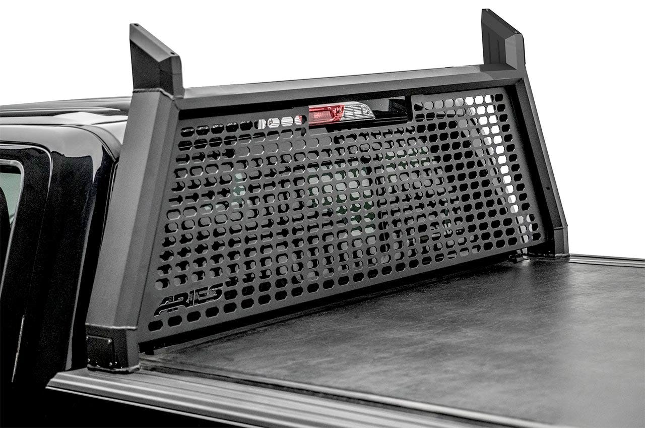 Black perforated metal headache rack mounted on truck bed behind cab with vertical supports and horizontal crossbars