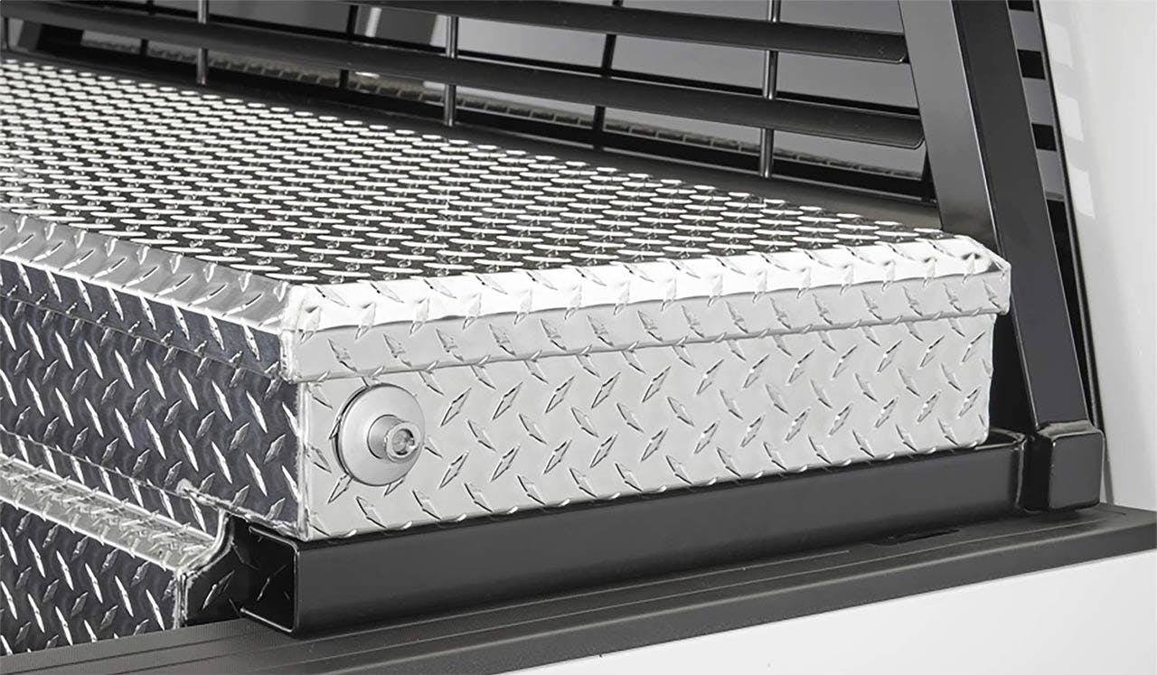 Polished aluminum truck toolbox mounted in bed with diamond plate surface and round lock mechanism visible on front face