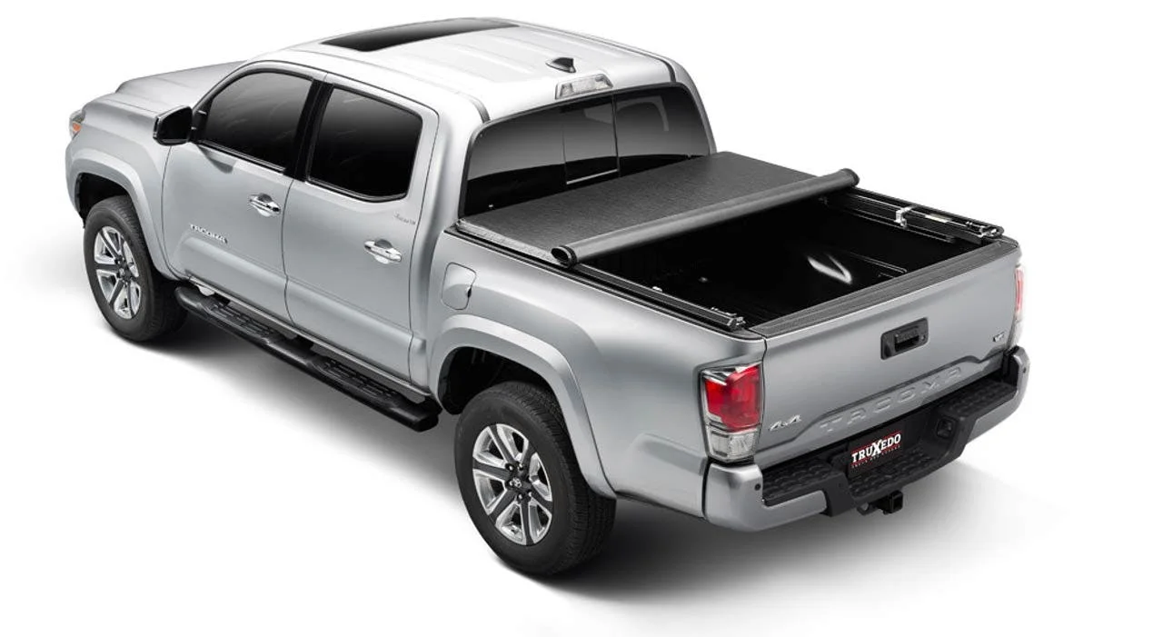Silver pickup truck with open rollup tonneau cover on truck bed, partially rolled back