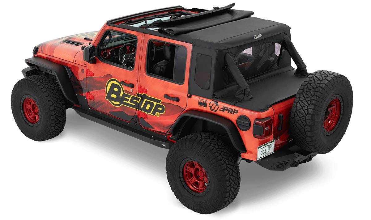 Red Jeep Wrangler with black soft top roof, removable doors, and large all-terrain tires.