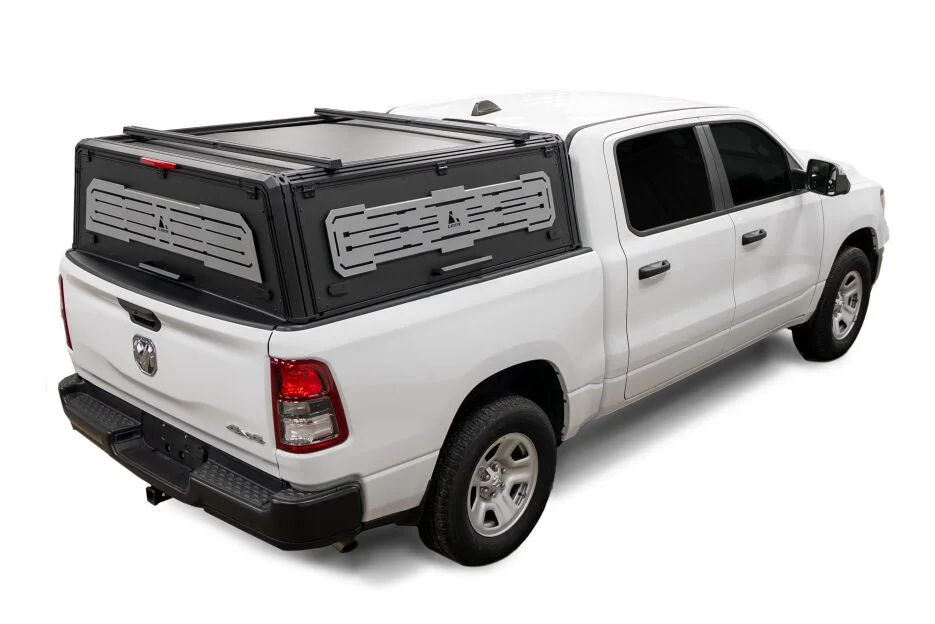 LEER NexCap modular metal cap with slotted accessory panels on a white Ram 1500, rear three-quarter driver side