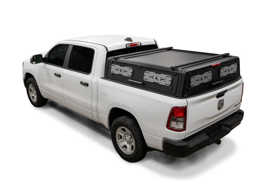 LEER NexCap Lo low-profile modular cap with a roll cover on a white Ram 1500, rear three-quarter driver side