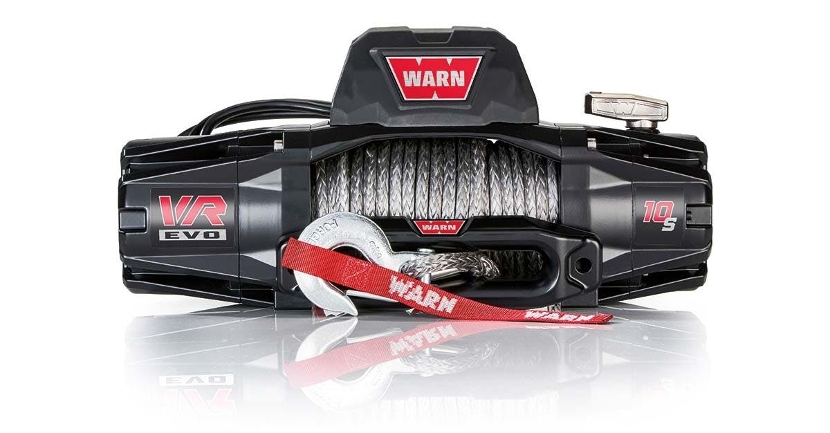 Black Warn VR EVO winch mounted on truck front with coiled synthetic rope and red strap attached