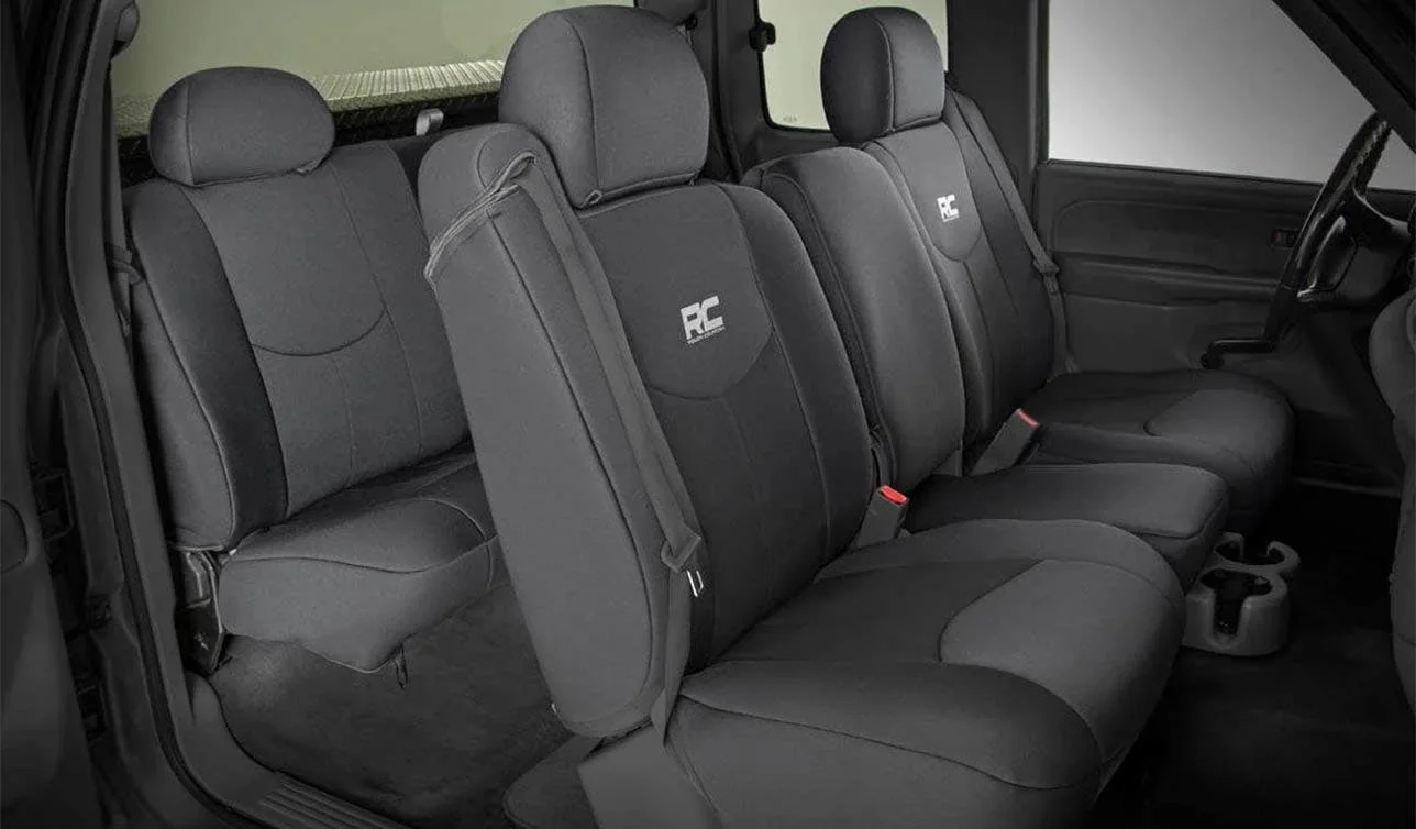 Dark gray neoprene seat covers with embroidered logo installed on truck cab front and rear seating