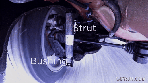 Close-up view of truck suspension components showing a strut and bushing assembly near the wheel