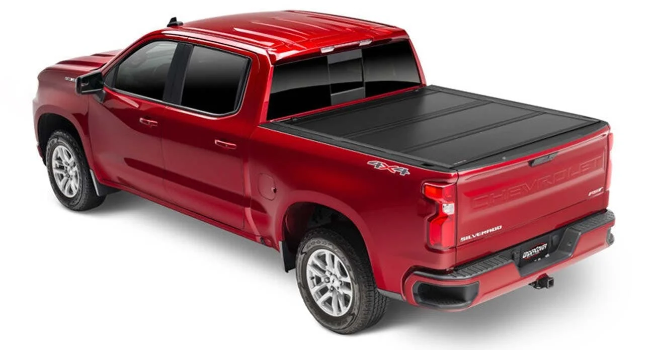 Red pickup truck with black tonneau cover over the bed and roof rack installed
