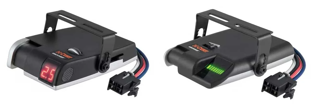 Two black trailer brake controllers side by side, left showing red digital display, right showing green battery indicator
