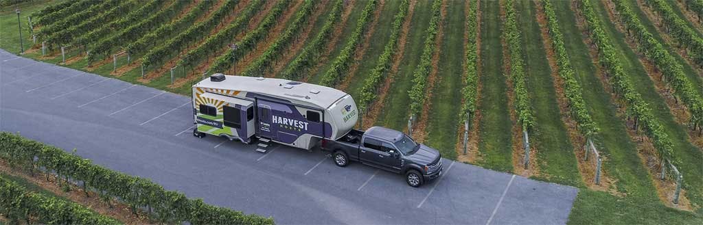 Black pickup truck towing a white utility trailer with