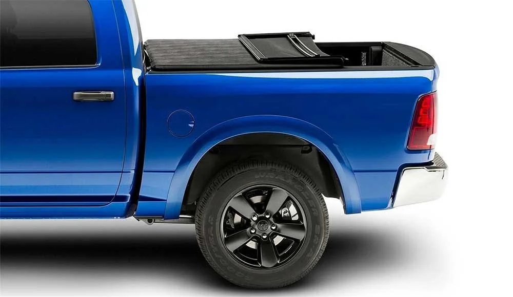 Blue pickup truck with black folding tonneau cover partially open over the bed