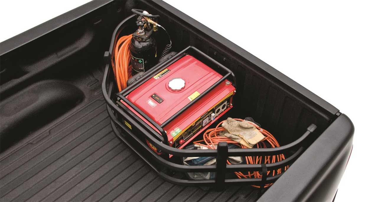 Red portable generator and coiled orange extension cords stored in a black truck bed organizer