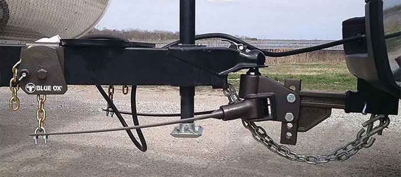 Blue Ox weight distribution hitch with chains and sway control bar mounted on trailer frame