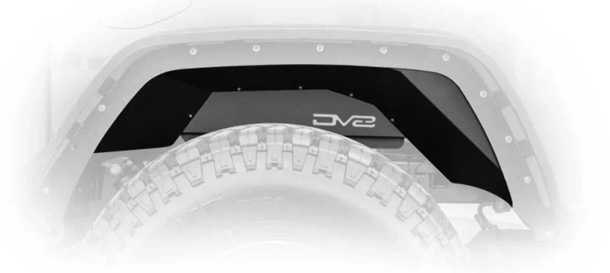 Black and gray wheel well guard installed on truck fender above a large all-terrain tire with tread pattern visible